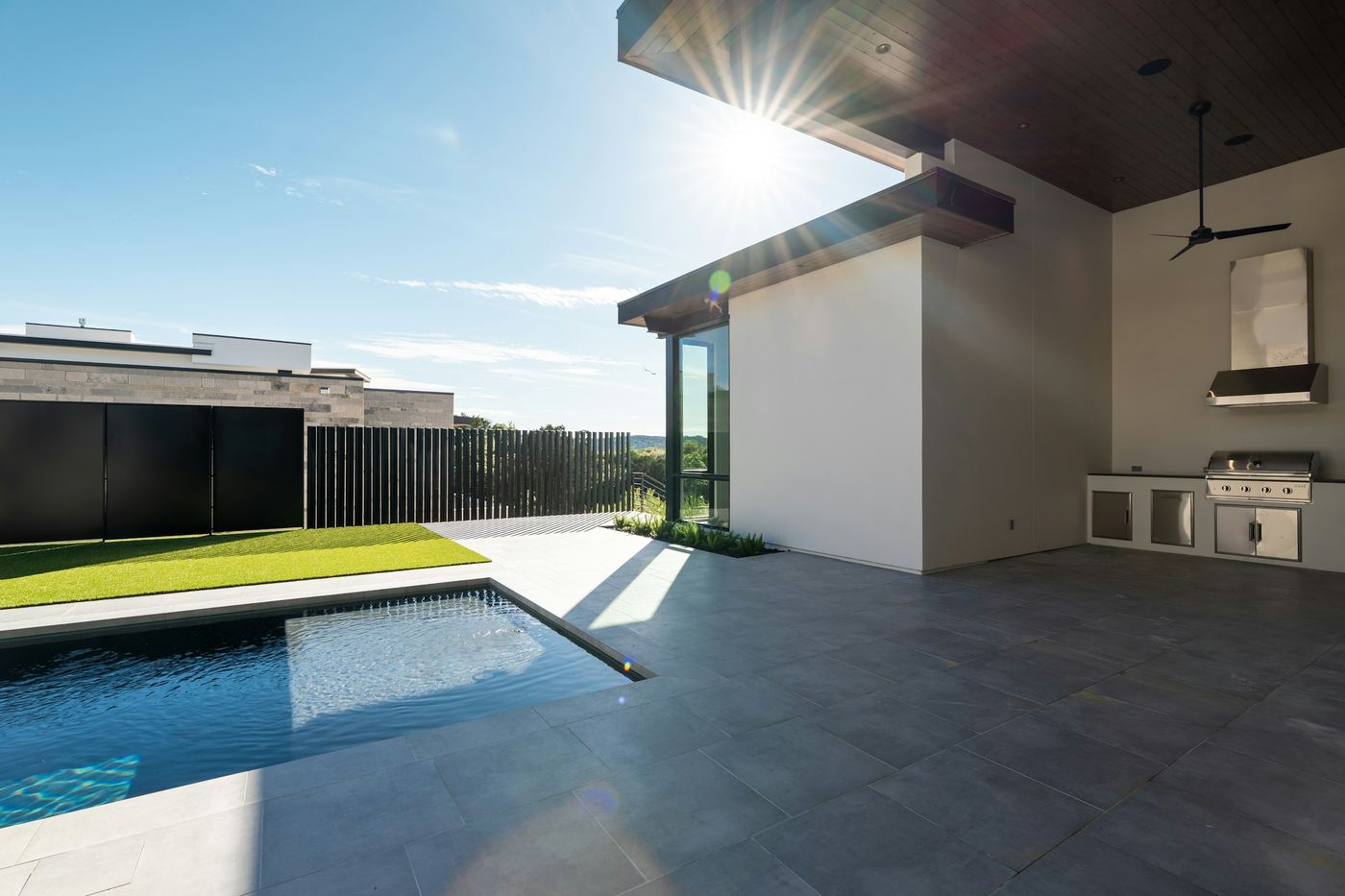 Pool beside an outdoor kitchen, in late afternoon sun