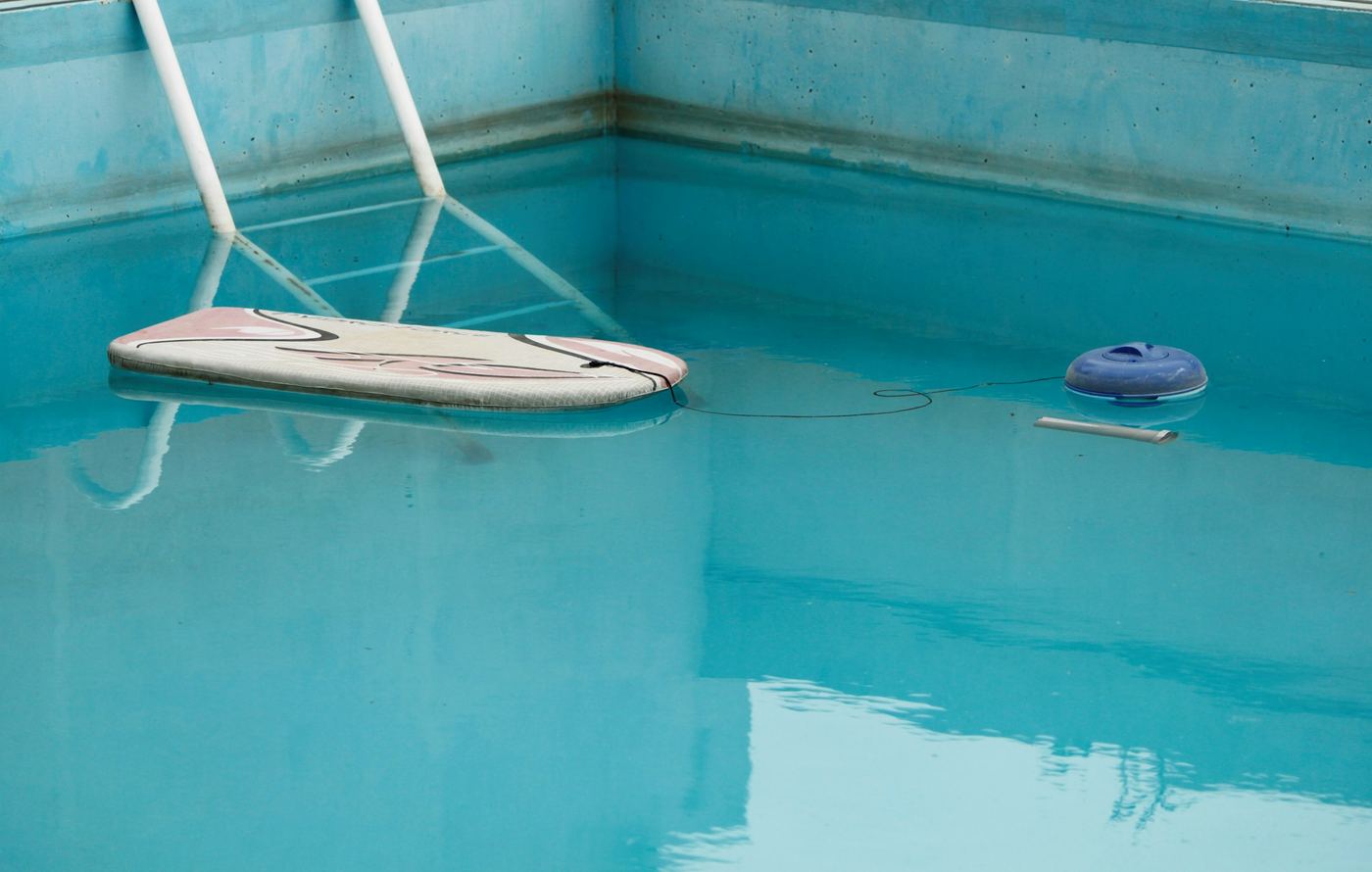 A skimmer net resting on the surface of a pool